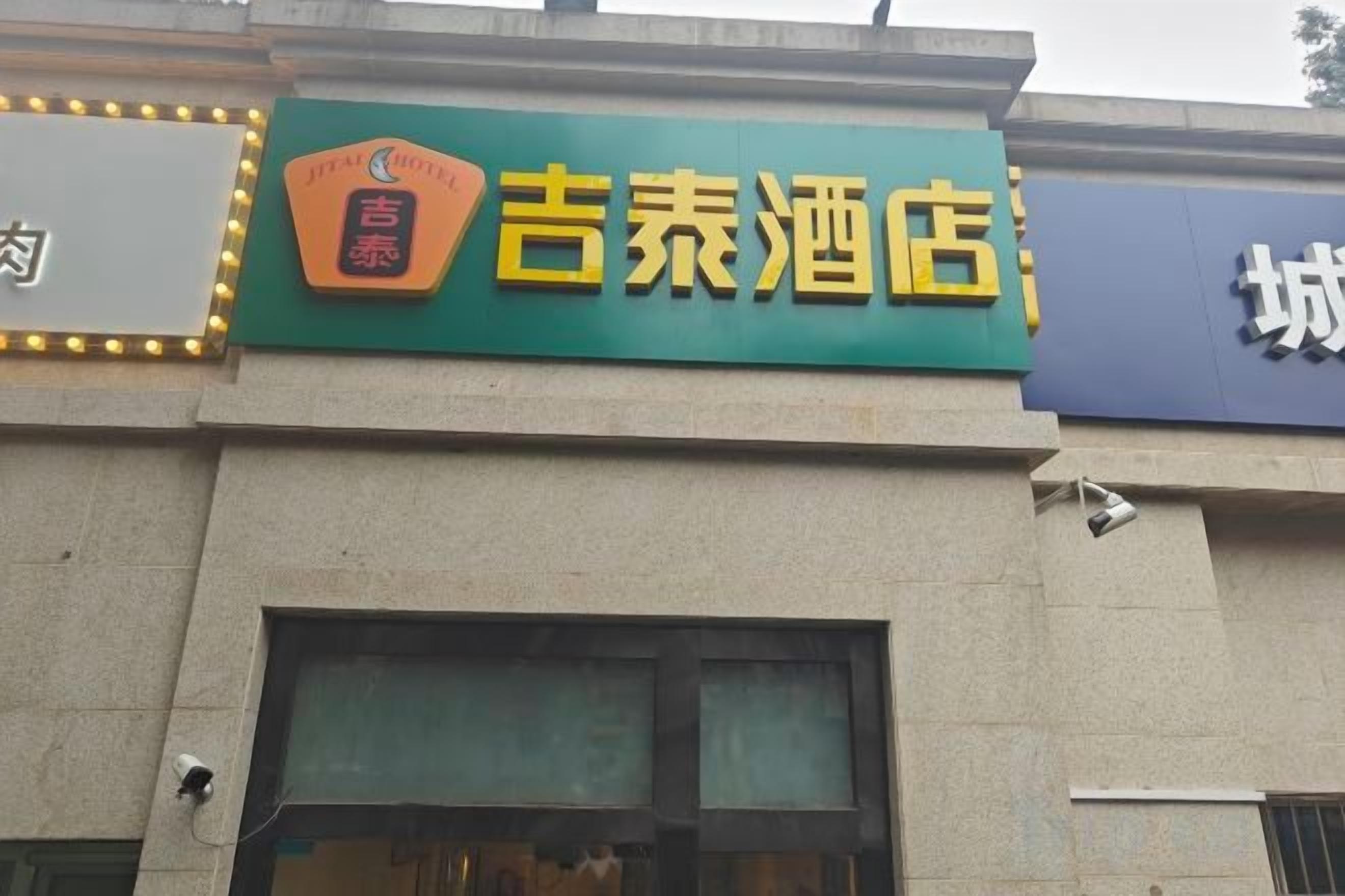 A building with a prominent sign for '吉泰酒店' (Jietai Hotel).