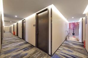 A hotel corridor with doors, carpeted floors, and a staircase. - Jitai Hotel (Beijing Tongren Hospital Zhanqian Square) (Beijing)