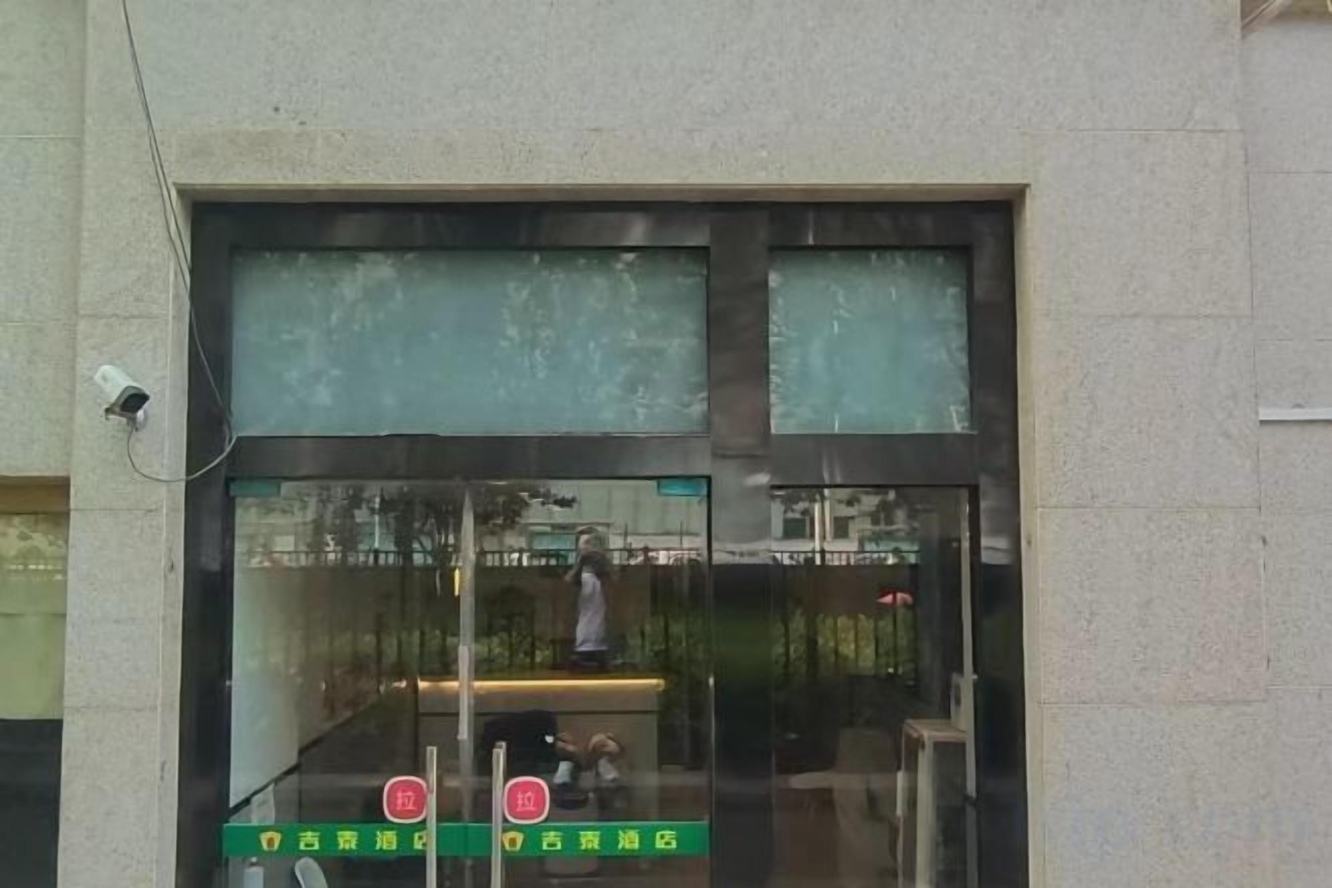 A building entrance with a glass door and a security camera.