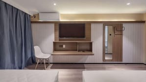 A modern hotel room with a bed, a desk, a chair, a TV, and a wardrobe. - Jitai Hotel (Beijing Tongren Hospital Zhanqian Square) (Beijing)