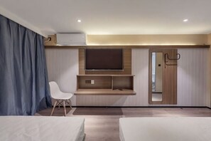 A modern hotel room with a bed, a desk, a chair, a TV, and a wardrobe. - Jitai Hotel (Beijing Tongren Hospital Zhanqian Square) (Beijing)