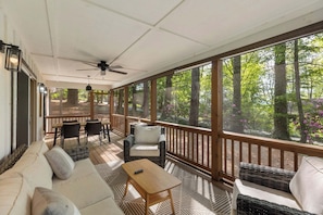 A covered porch with a ceiling fan, wicker furniture, and a view of a forest. - 2bd/2ba Cashiers 5 min. New remodel, one level, pet friendly (Glenville)