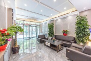 Un vestíbulo moderno con mostrador de recepción, zona de estar y entrada de vidrio.