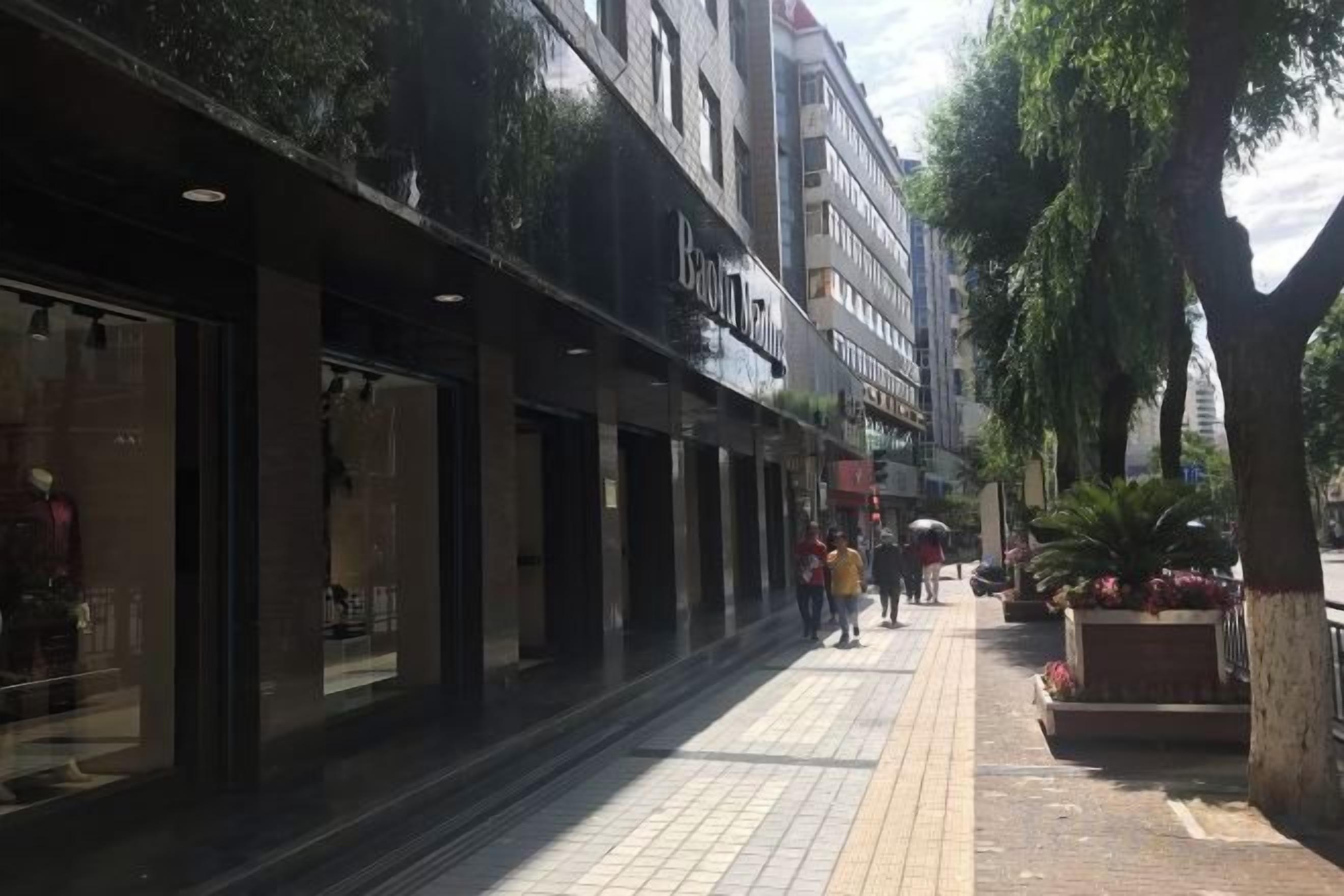Una acera bordeada de comercios, incluyendo una tienda 'Beauty'.