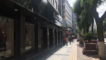 Una acera bordeada de comercios, incluyendo una tienda 'Beauty'.