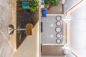 A top-down view of a hotel room with a dining area, a bar, and a clock on the wall.