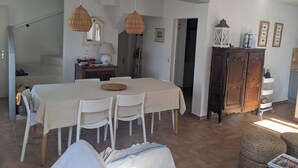 A dining area with a table, chairs, and hanging light fixtures.