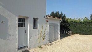 A white building with a garage, a small window, and a door.