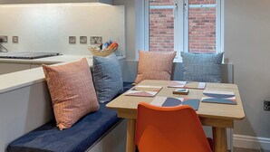 A modern kitchen with a built-in bench and a dining table with geometric placemats. - 3 bedroom accommodation in Whitby (Whitby)