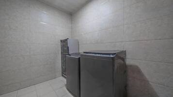Un espacio pequeño y cerrado para lavandería con dos lavadoras y una secadora.