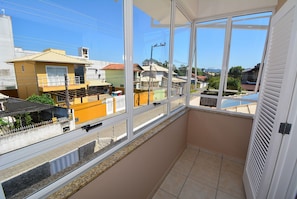 Ein Balkon mit Blick auf benachbarte Häuser und einen klaren Himmel.