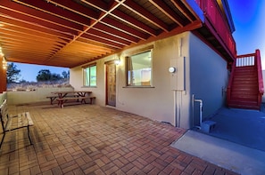 A covered patio with a picnic table and a red gate. - Private Hilltop Retreat w/ 360° Verde Valley Views (Rimrock)