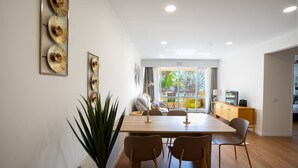 A modern dining area with a wooden table, four chairs, and a potted plant. - Solar do Mar by LovelyStay (Funchal)