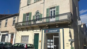 Ein Gebäude mit einer Schaufensterfront mit der Aufschrift 'coprosud' und einer grünen Tür.