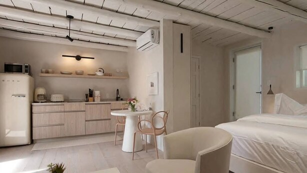 Habitació moderna i funcional amb cuineta, zona de menjador i llit.