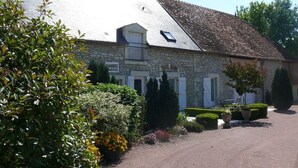 Un bâtiment en pierre avec un toit en pente, un balcon et une enseigne sur laquelle on peut lire « CHANDRES HÔTES ».