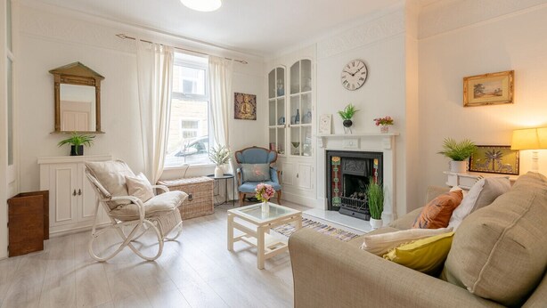 Una sala de estar con chimenea, un sofá, una silla y una mesita de centro.