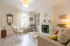 A living room with a fireplace, a sofa, a chair, and a coffee table.