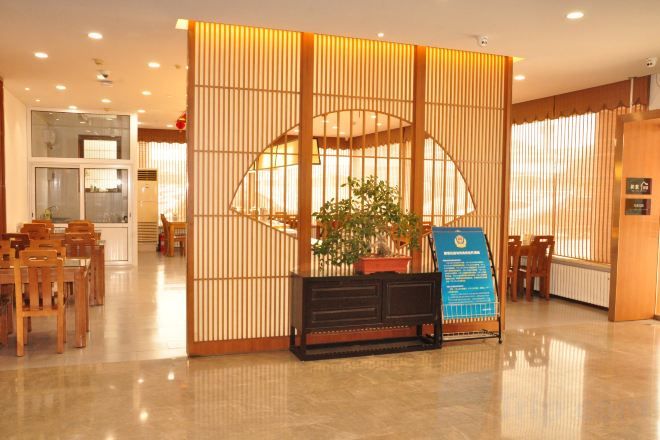 A reception area with a traditional Japanese-style partition, a reception desk, and a potted plant.