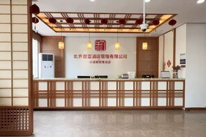 A reception desk with a wooden design, a ceiling with red lanterns, and a sign with Chinese characters. - Hejia Inn Beijing Sijiqinq (Beijing)