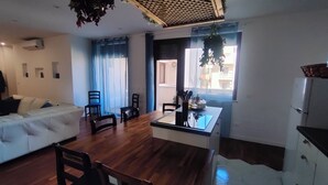 A modern living space with a dining area, a sofa, and a kitchen counter. - Elegant Apartment with Terrace – A Peaceful Oasis in Palermo (Palermo)