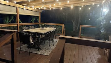 Enjoy dining al fresco on the patio, surrounded by lush greenery and string lights.