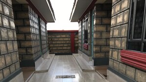 Ein Korridor mit Fliesenboden, Backsteinwänden und einer roten Bank.