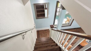 A wooden staircase with white railings leading to a landing.