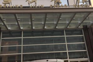A hotel with a modern facade, large windows, and a sign indicating it is a hotel. - Xuesong Hostel (Beijing)