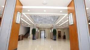 A spacious lobby with a high ceiling, recessed lighting, and a central decorative panel. - Xuesong Hostel (Beijing)