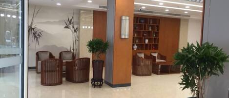 A lobby with seating, a reception desk, and a bookshelf.