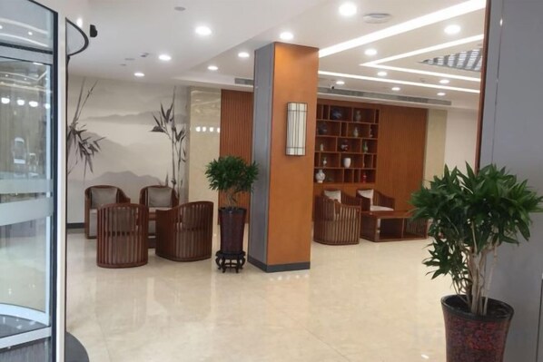 A lobby with seating, a reception desk, and a bookshelf.
