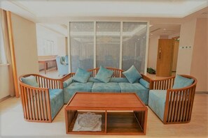 Een moderne woonkamer met een modulaire bank, een houten salontafel en een groot raam.