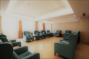 A spacious room with rows of green chairs and a high ceiling. - Xuesong Hostel (Beijing)
