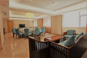 A modern living room with a dining area, a sofa set, and a television. - Xuesong Hostel (Beijing)