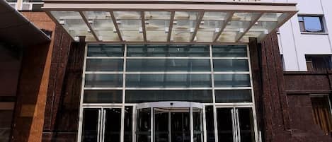 A hotel entrance with a revolving door and large glass windows.