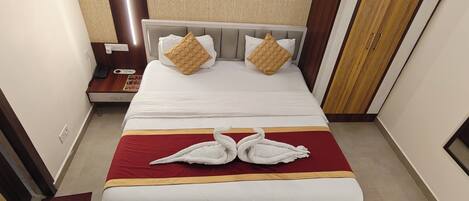 A hotel room with a bed, a nightstand, a telephone, and a wardrobe.