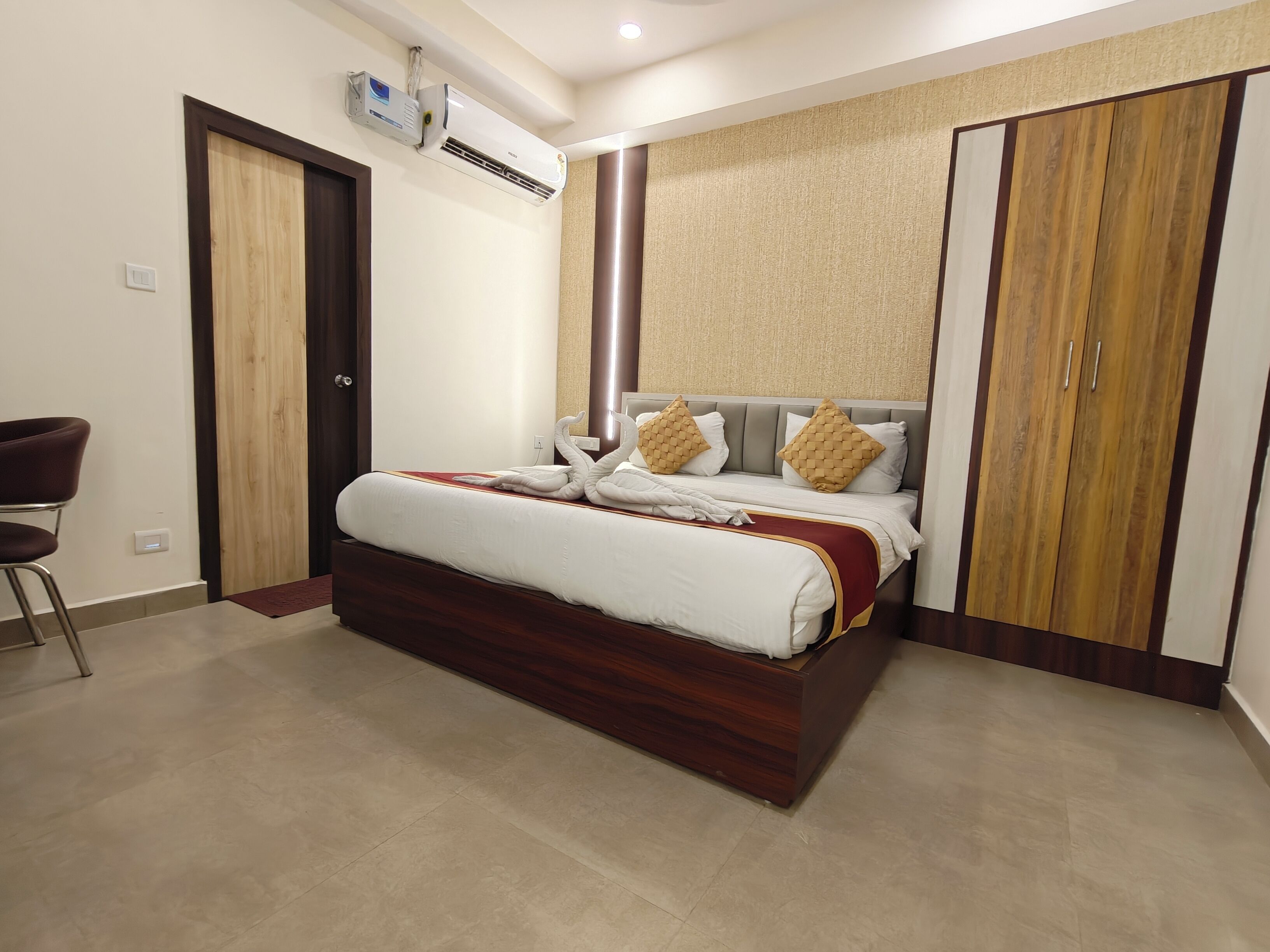 Une chambre d’hôtel équipée d’un lit, d’une chaise, d’une armoire et d’un appareil de climatisation.