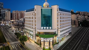 Un hôtel doté d’une façade en verre remarquable, de plusieurs étages et surmonté d’un dôme.