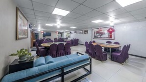 A conference room with multiple tables and chairs, a sofa, and framed artwork on the walls. - Yilang Hotel (Shanghai)