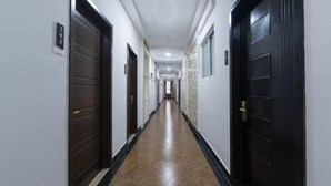 A long, narrow hallway with dark wooden doors on both sides, leading to individual rooms. - Yilang Hotel (Shanghai)
