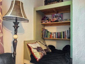 A room with a bed, a lamp, and a bookshelf with books and toys. - 3 bedroom accommodation in Ashbourne (Ashbourne)