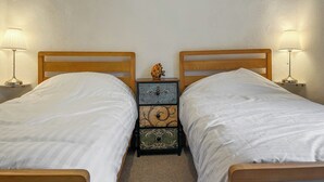 A double bed with a wooden headboard, a nightstand with a lamp, and a decorative box between the beds. - 3 bedroom accommodation in Ashbourne (Ashbourne)