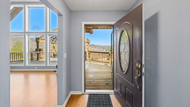 A hallway leading to a deck with a view of a mountainous landscape.