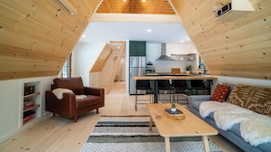 Ein Loft-Wohnraum mit Küche, Holzboden und einer gemütlichen Sitzecke inklusive Sofa und Couchtisch.