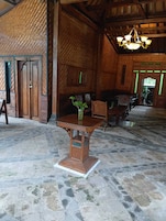 Un interior rústico con suelo de piedra, muebles de madera y una araña.