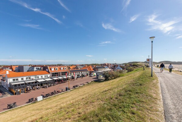 A coastal town with buildings, a paved walkway, and a view of the sea. - Coastal Holiday Base in Zoutelande for 4 (Zoutelande)