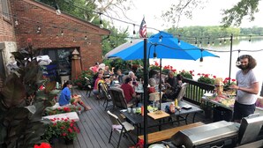 A deck with outdoor seating, a grill, and a view of a body of water. - Spacious room in Tudor home overlooking the Maumee river near Metro Parks. Wifi (Grand Rapids)
