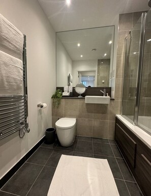 Bathroom features a toilet, shower enclosure, and towel rack.