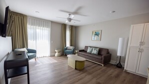 Ein modernes Wohnzimmer mit einer Couch, einem Sessel, einem Couchtisch und einem Fernseher.